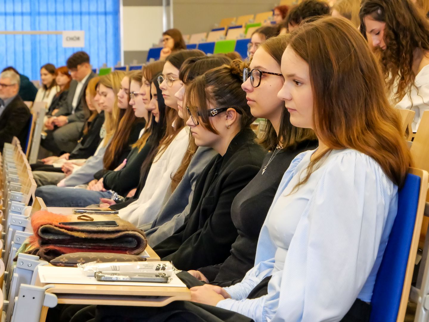 Szeroki widok na siedzących studentów w jednym rzędzie