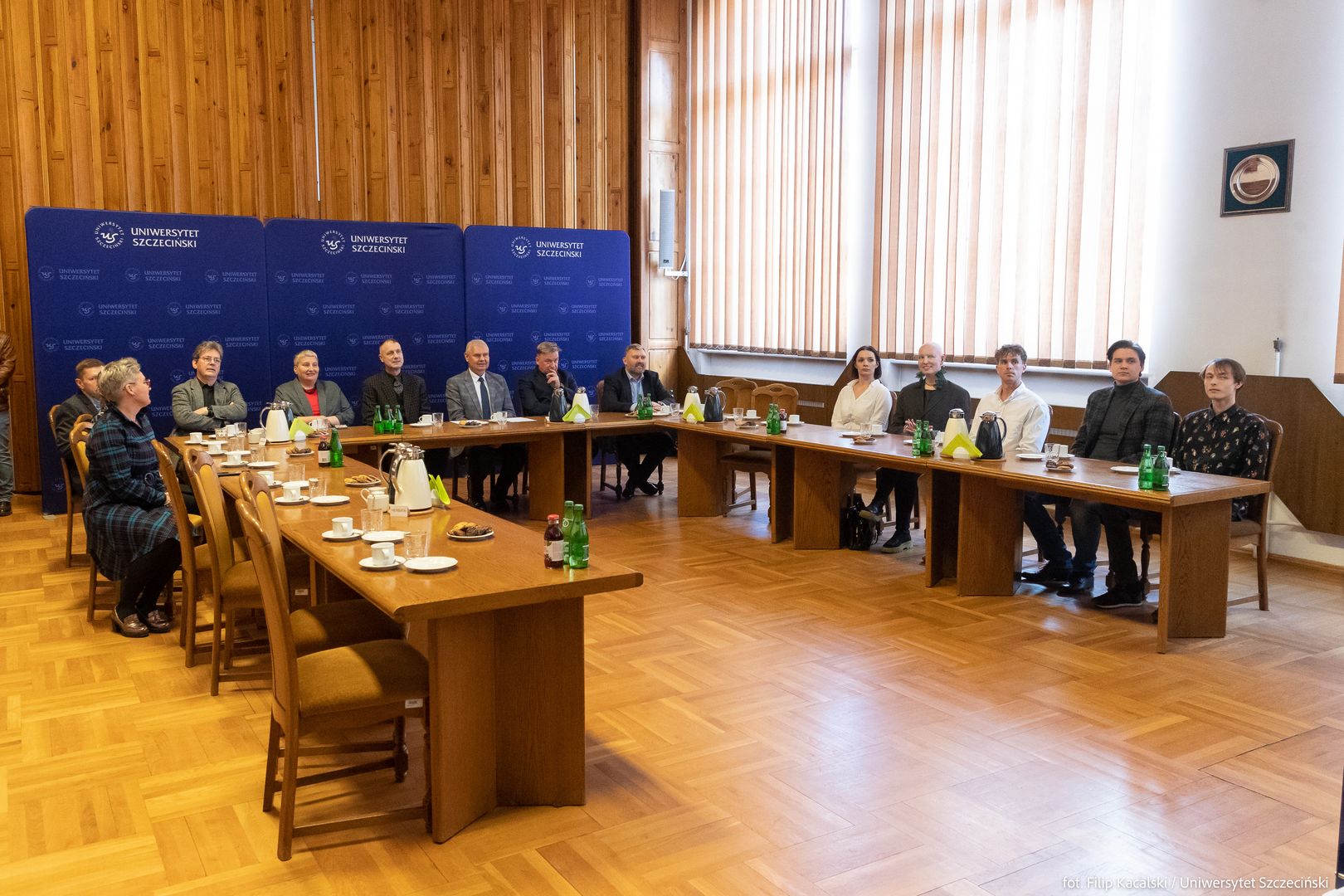 Grupa siedzących osób - uczestnicy spotkania